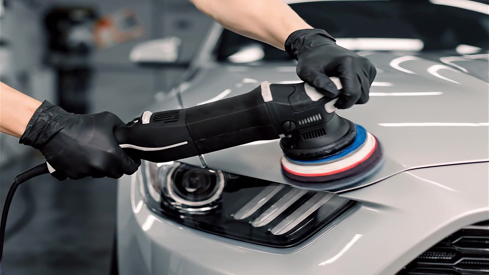 Polijstmachine op de voorkant van een zilvergrijze auto