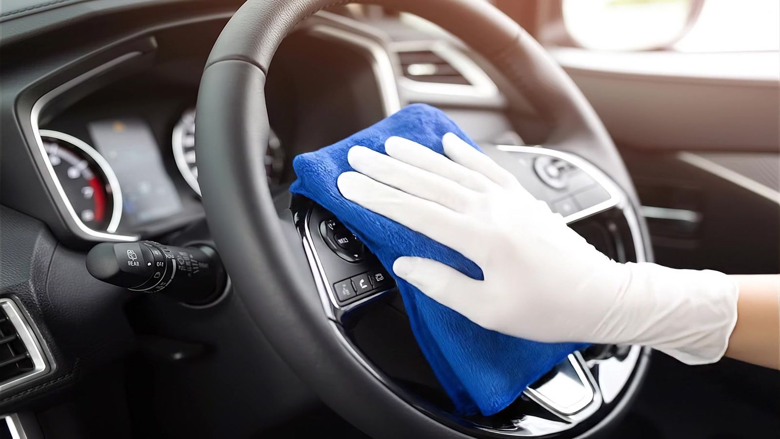 Blauwe doek op het stuurwiel van een auto tijdens de reiniging